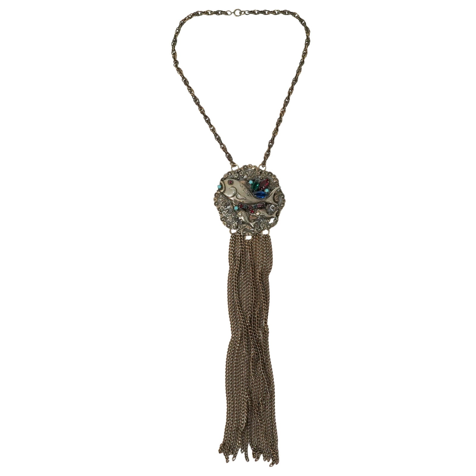 1970s Three Fish Medallion Pendant Necklace: 1970s Three Fish Medallion Pendant Necklace 1970s, USA Vintage necklace featuring a silver metal openwork medallion with three stylized fish, accented with various colored rhinestones and long bronze-
