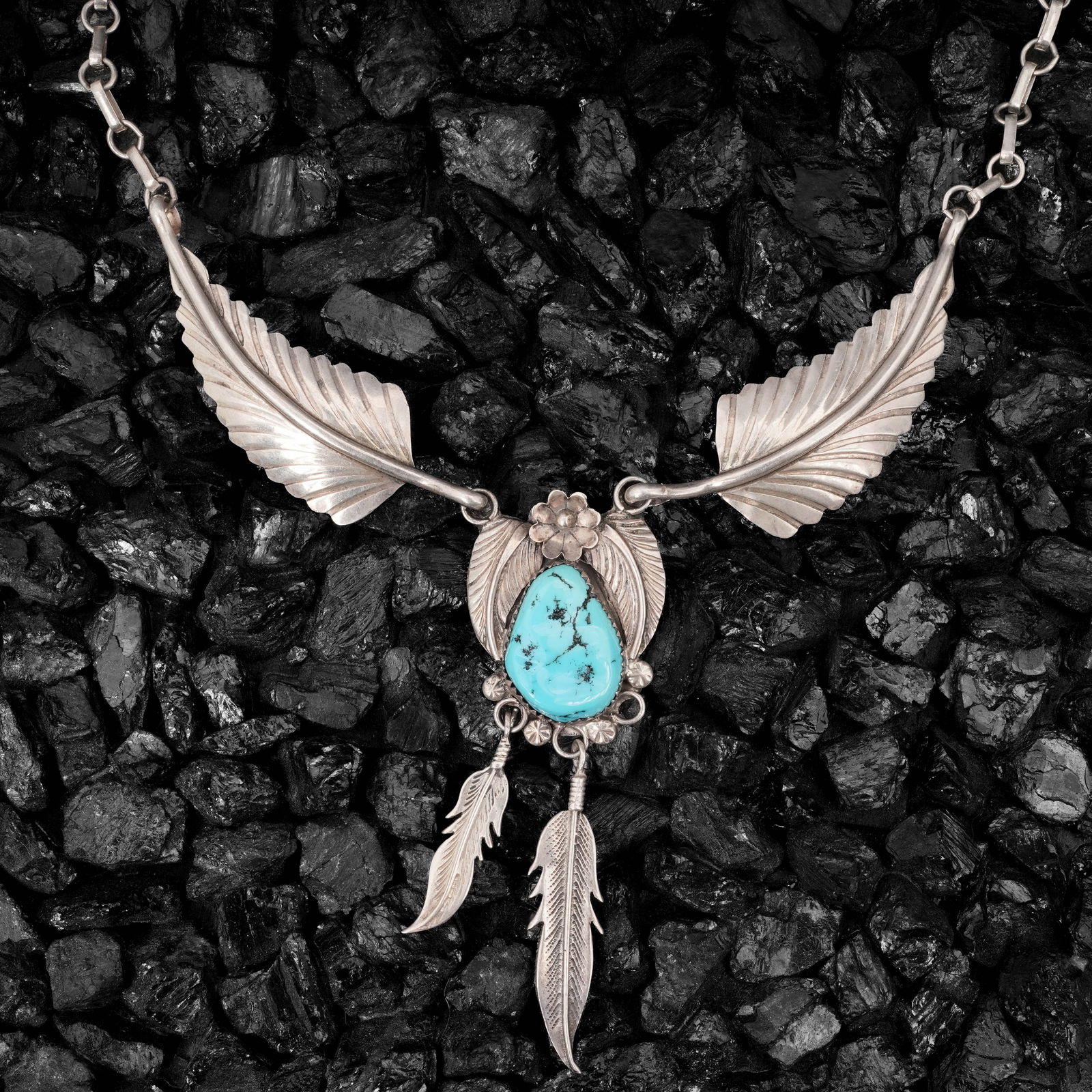 Vintage Navajo Sterling Silver & Turquoise Feather Dangle Necklace: Vintage Navajo Sterling Silver & Turquoise Feather Dangle NecklaceCirca 1970s-1980s, USAVintage Navajo sterling silver necklace featuring a feather and leaf motif with a natural turquoise cabochon cen