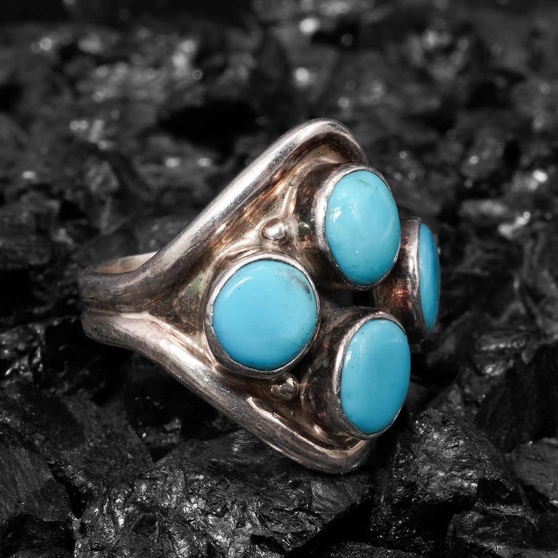 Carol Felley Navajo Sterling Silver Turquoise Cluster Ring: Carol Felley Navajo Sterling Silver Turquoise Cluster RingCirca 1994, USASterling silver ring centered by a four-stone turquoise cabochon cluster, approximately 8 Ã— 6 mm each in smooth bez