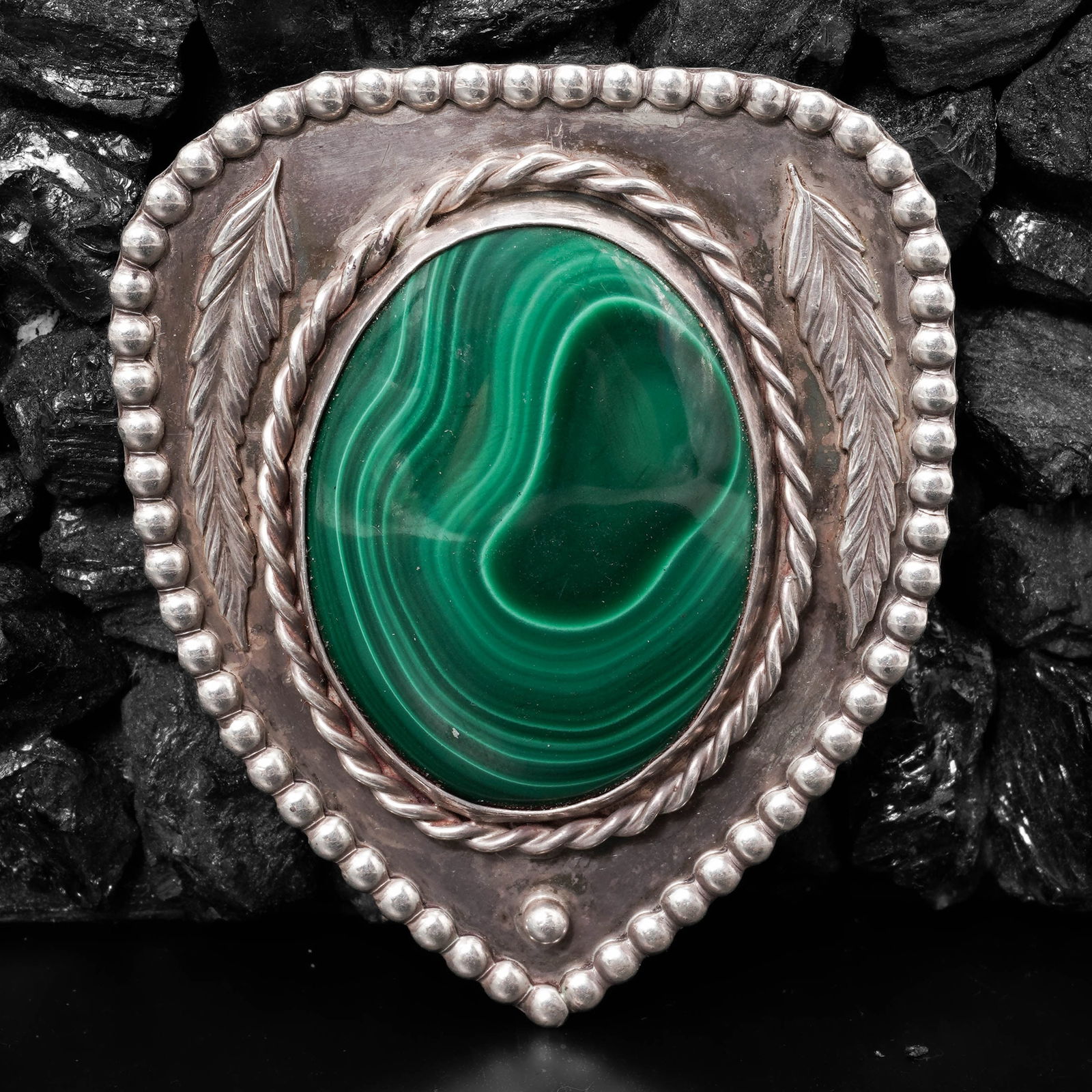 Vintage Navajo Sterling Silver & Malachite Bolo Tie: Vintage Navajo Sterling Silver & Malachite Bolo TieCirca 1970s-1980s, USAVintage sterling silver Navajo bolo tie with a decorative teardrop-shaped slide featuring an oval malachite cabochon measuring