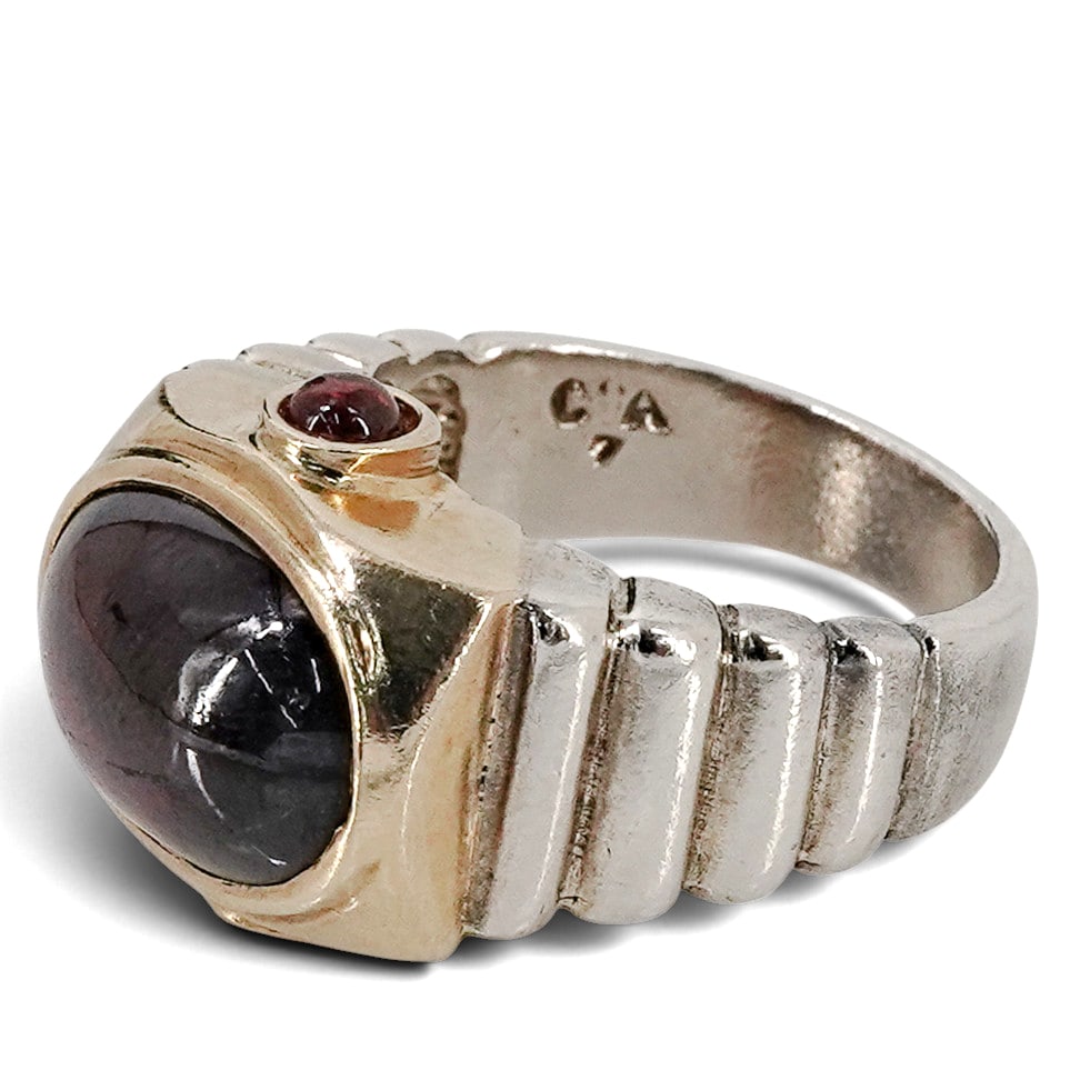 14k Gold & Sterling Garnet Cabochon Ring: 14k Gold & Sterling Garnet Cabochon Ring Late 20th-early 21st century A 14k gold and sterling silver ring with garnet cabochon in center and accent stones. Marked on band "14k", "925", "7", with "CA" 