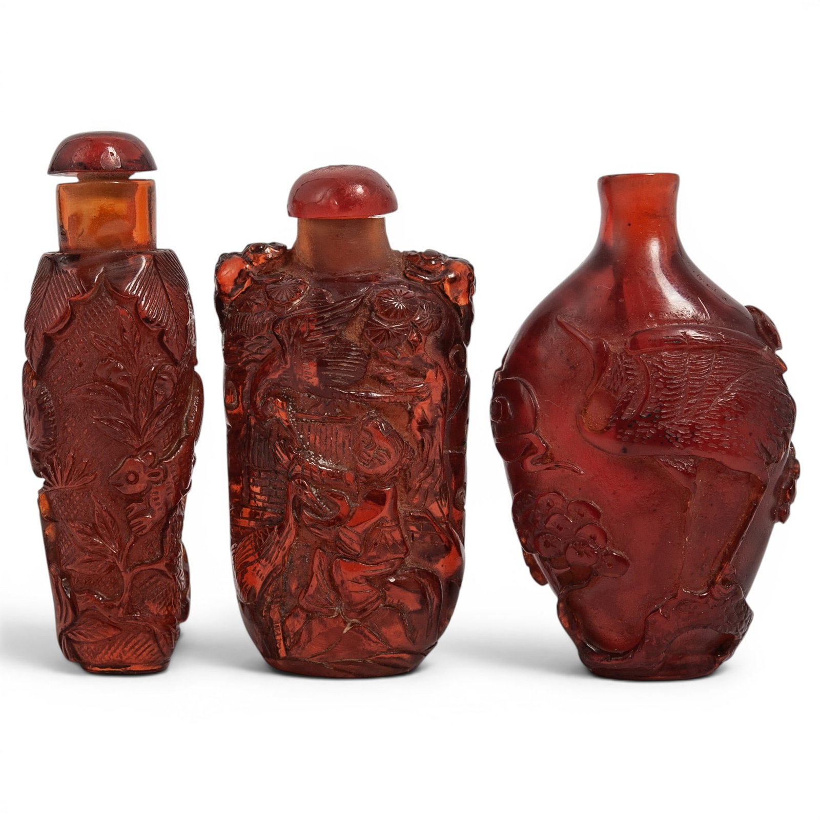 (3 pcs) Chinese Carved Amber Resin Snuff Bottles: (3 pcs) Chinese Carved Amber Resin Snuff Bottles 20th century, Chinese A set of three Chinese carved red amber colored resin snuff bottles. (1) Carved with squirrels and raised floral motifs. Measurem