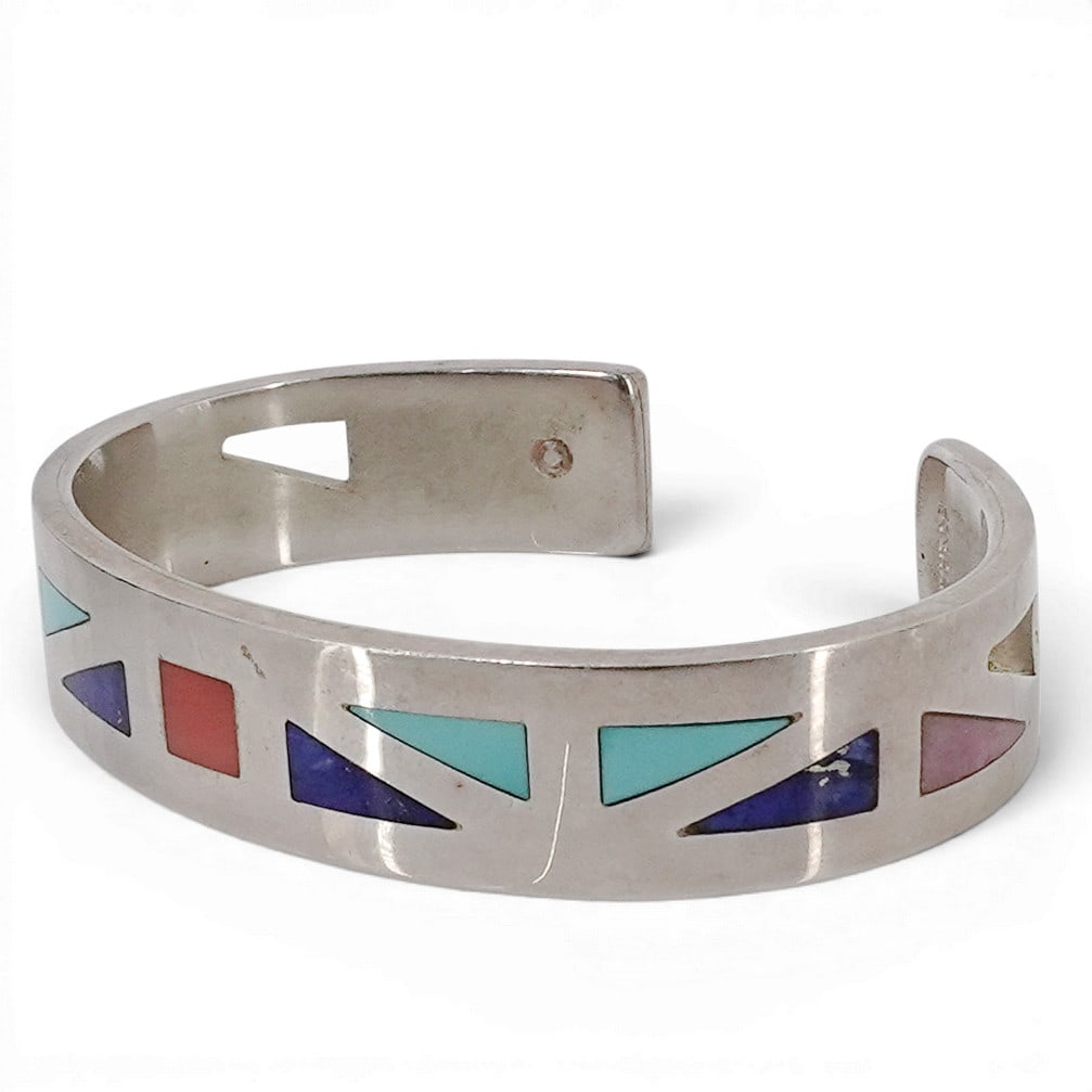 Navajo Inlaid Stone Sterling Silver Cuff: Navajo Inlaid Stone Sterling Silver Cuff Late 20th-early 21st century A Navajo sterling silver cuff with geometric inlaid stone detailing. Marked "sterling" and "C" inside band and etched signature