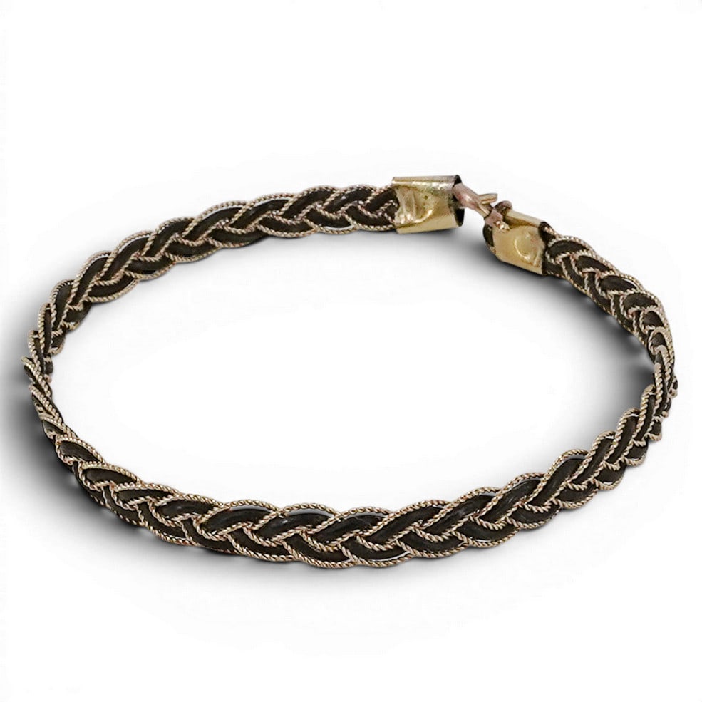 Antique Braided Elephant Hair & Gold Tone Bracelet: Antique Braided Elephant Hair & Gold Tone Bracelet 20th Century Antique bracelet featuring tightly braided elephant hair accented by gold-tone wirework and decorative end mounts. Fits: 7.5", W: 0.25"