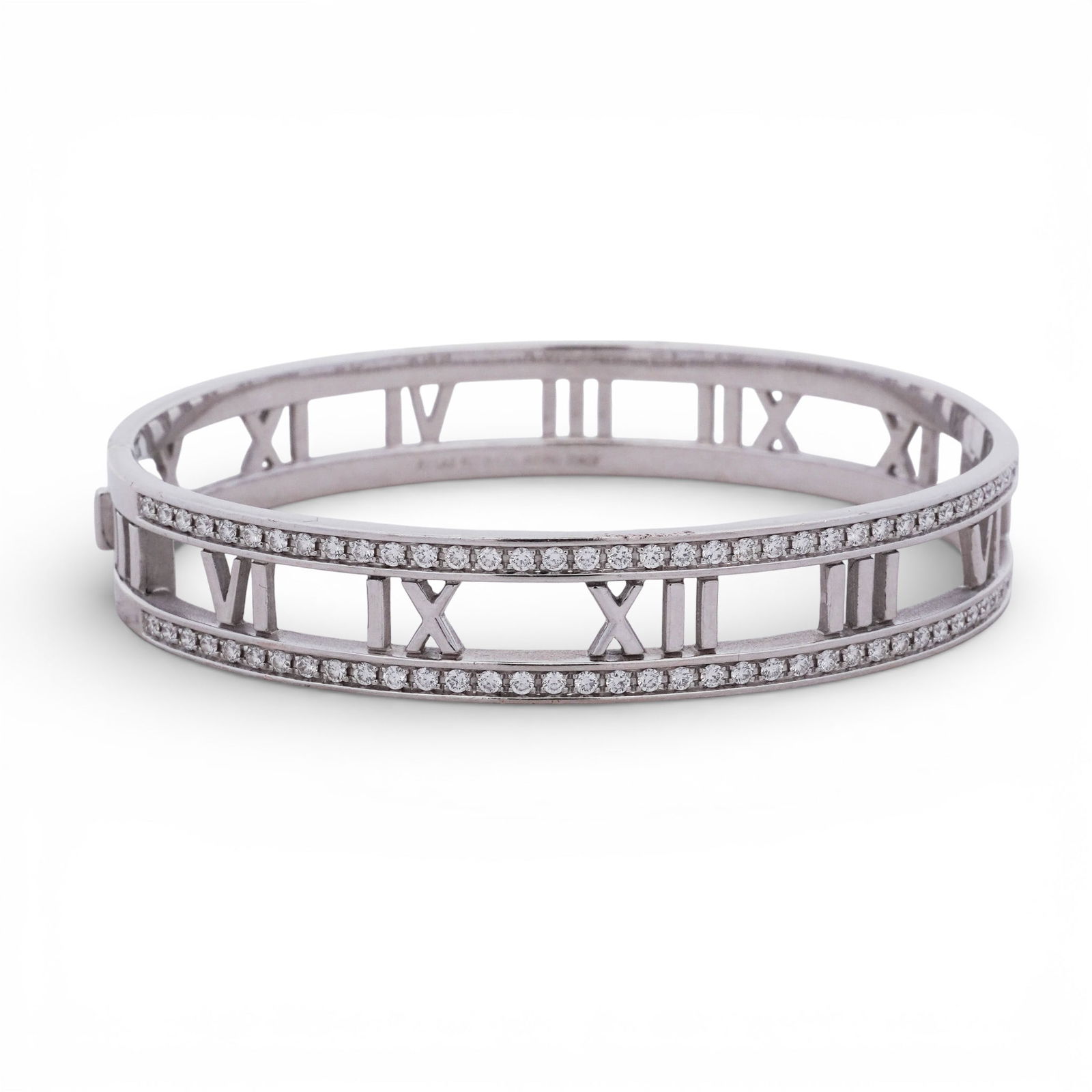 Tiffany & Co. "Atlas" Diamond Bracelet: Tiffany & Co. "Atlas" Diamond Bracelet2000s, USA18k white gold open hinged bangle from Tiffany & Co.’s Atlas collection, designed with openwork Roman numeral motifs around the circumference. The upp