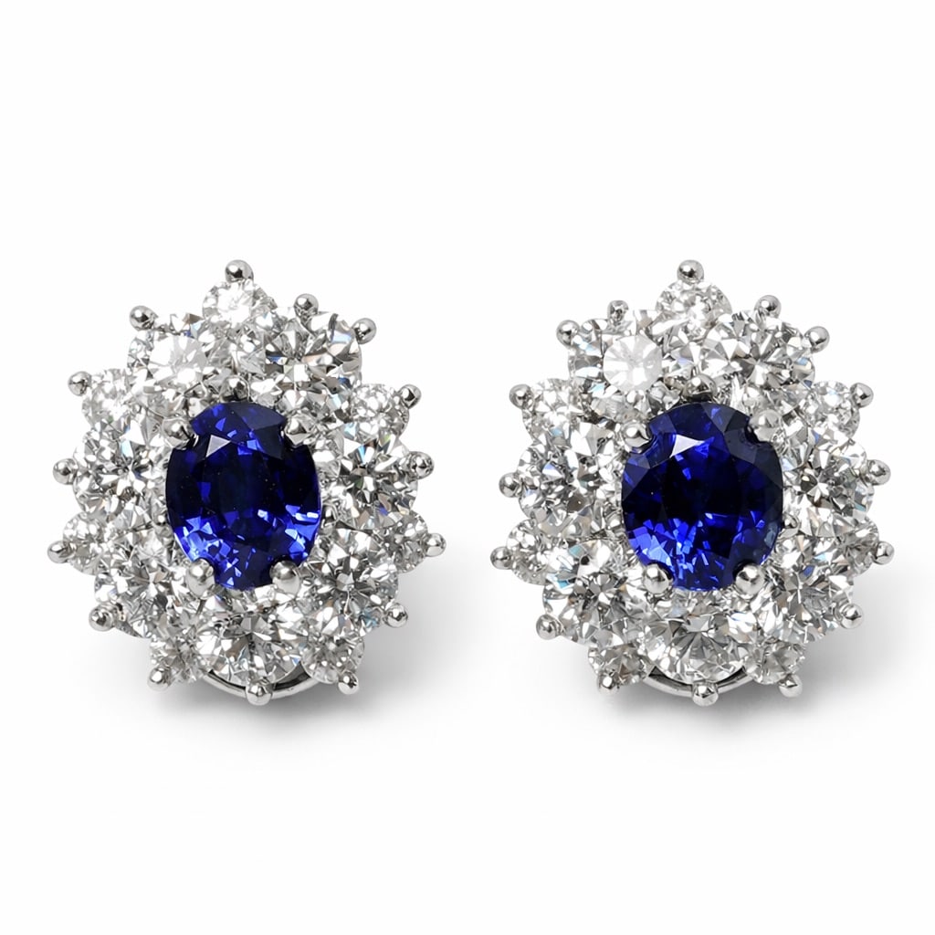 Tiffany & Co. Platinum Sapphire & Diamond Cluster Earrings: Tiffany & Co. Platinum Sapphire & Diamond Cluster EarringsCirca: 1980s, USA.Tiffany & Co. platinum cluster earrings, each centering an oval natural blue sapphire weighing approximately 2.00 ct total.