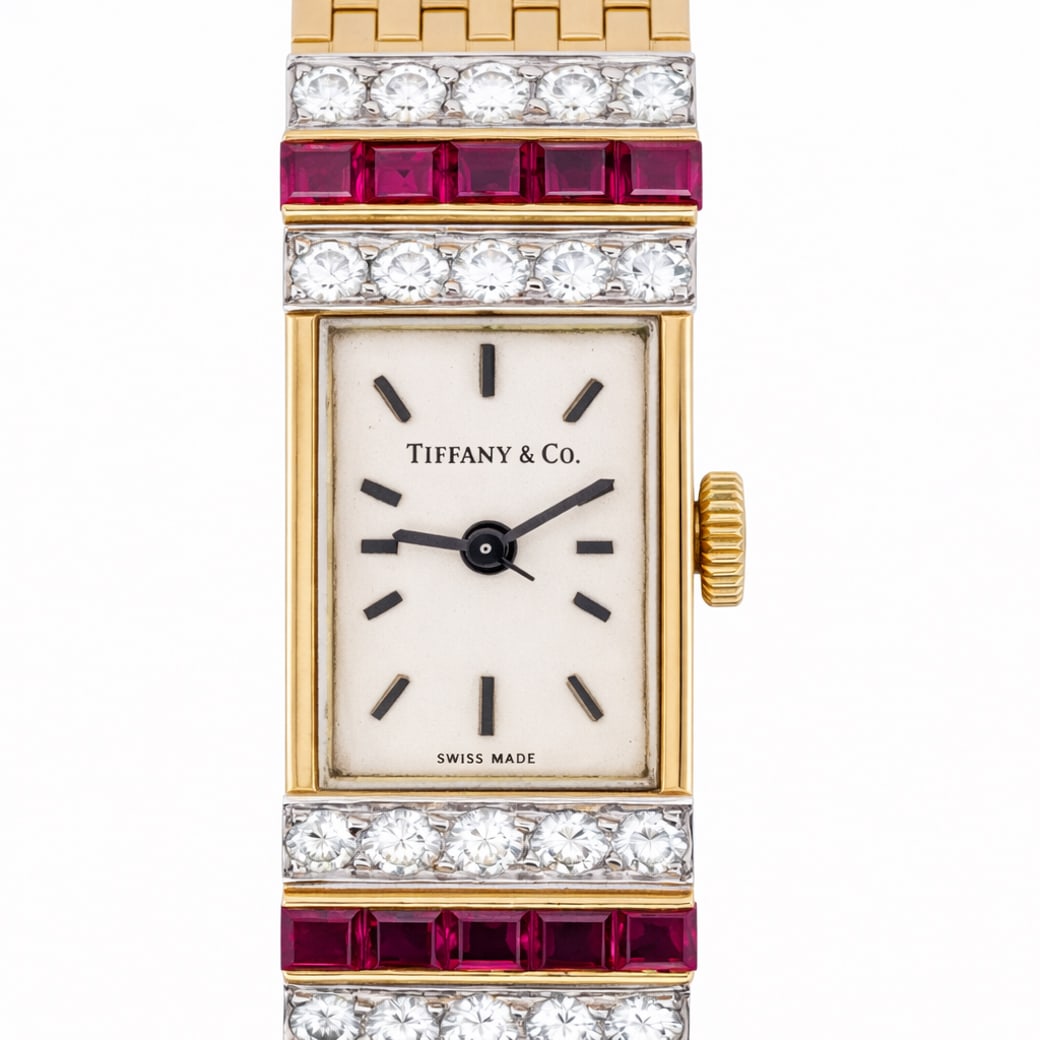 Vintage Tiffany & Co. 18k Gold Diamond & Ruby Watch: Vintage Tiffany & Co. 18k Gold Diamond & Ruby Watch1950s, SwissA vintage 18k gold Tiffany & Co. watch features a manual wind movement, 17 jewels, white dial, decorated with rows of diamonds and rubies