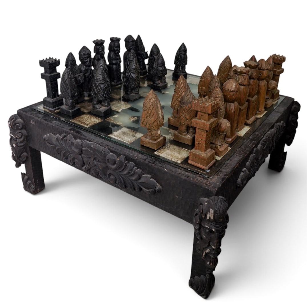 Vintage Hand-Carved Figural Folk Art Chess Set & Table: Vintage Hand-Carved Figural Folk Art Chess Set & Table Mid-Late 20th Century, Hand-carved folk art chess table featuring bold carved faces and scrolling foliate motifs on each apron and leg, surmounte