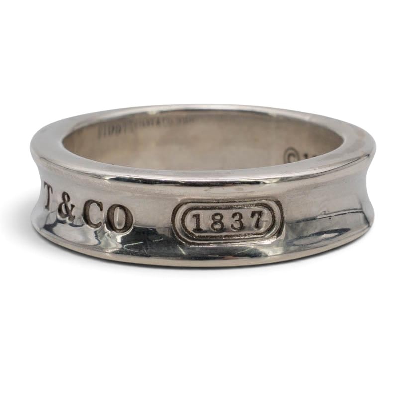 Tiffany & Co. 1837 Sterling Silver Concave Band Ring: Tiffany & Co. 1837 Sterling Silver Concave Band Ring 1997, USA Tiffany & Co. 1837 concave band ring in sterling silver with a polished indented profile, raised edges, and exterior logo detailing. Stam