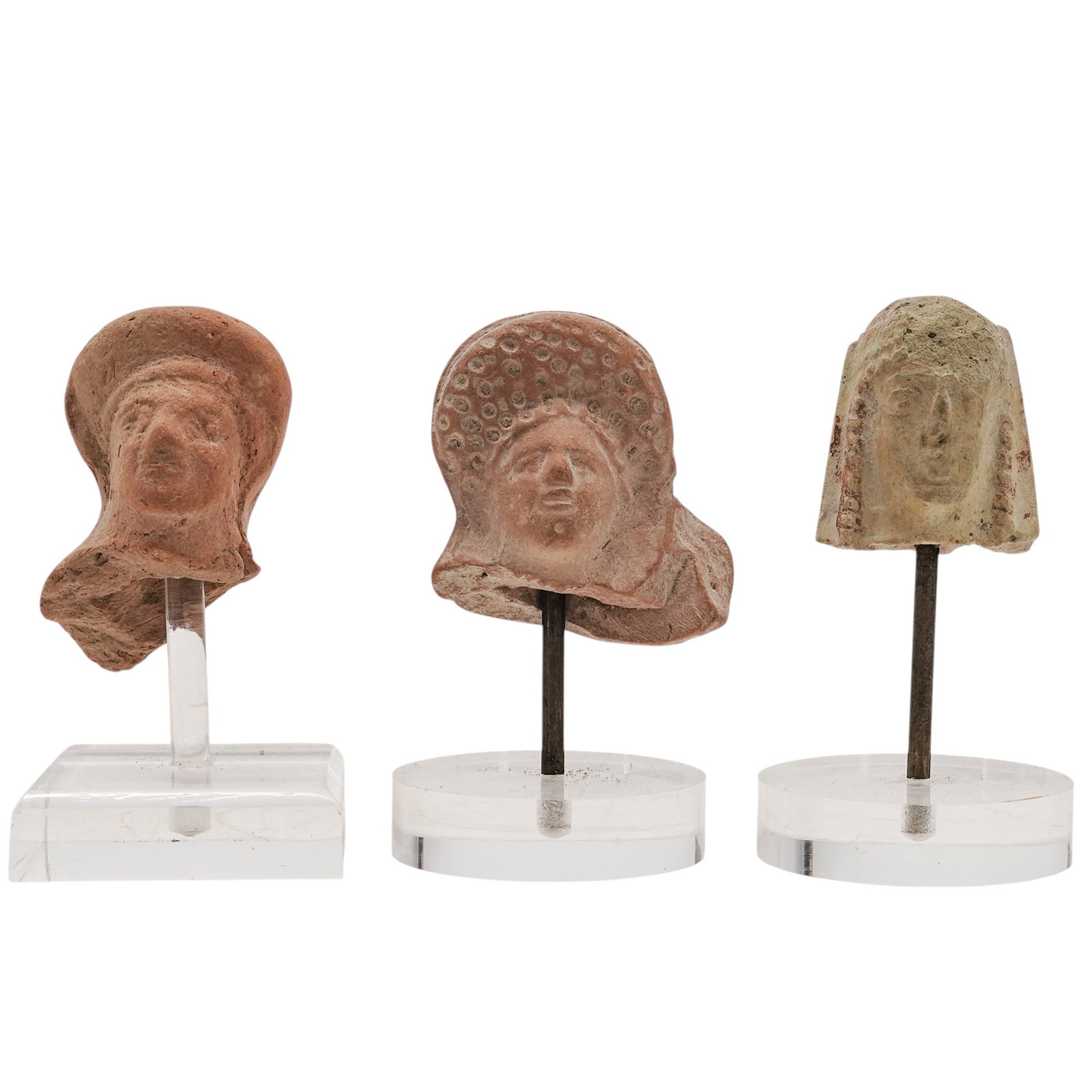 (3 pc) Ancient Mediterranean Female Terracotta Busts: (3 pc) Ancient Mediterranean Female Terracotta Busts Approx. c. 550 BCE-200 CE, Mediterranean Basin A three-piece grouping of a late Classical Etruscan female votive head enveloped in a deep, high-wal