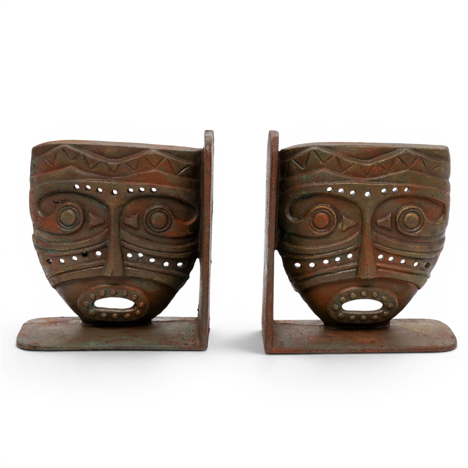 Pair Of Vintage Patinated Iron Tribal Mask Bookends: Pair Of Vintage Patinated Iron Tribal Mask Bookends Mid 20th Cent. The bookends feature a high-relief, stylized mask motif detailed with textured geometric patterns, dotted accents, and cutout eyes