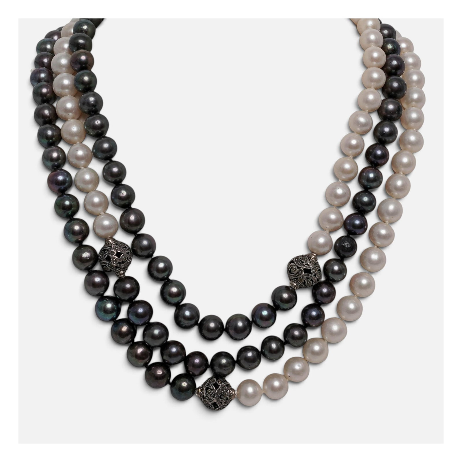 Designer Signed Multi-Strand Sterling & Pearl Necklace: Designer Signed Multi-Strand Sterling & Pearl Necklace 20th Cent. A multi-strand pearl necklace featuring a striking contrast of classic white and dark peacock-black pearls. It incorporates detailed,