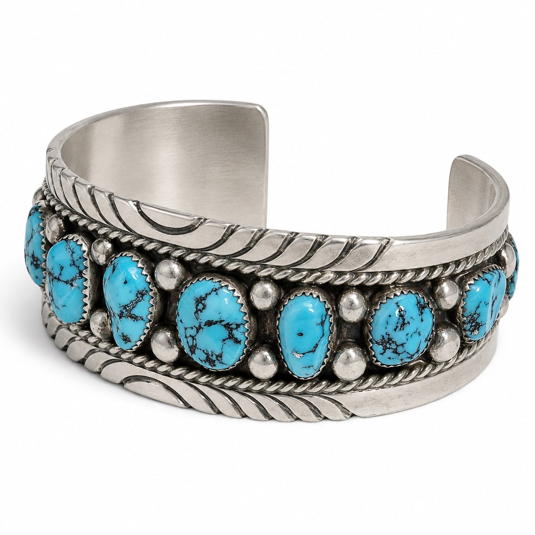 Tommy Moore Navajo Sterling Silver & Turquoise Cuff: Tommy Moore Navajo Sterling Silver & Turquoise Cuff 1970-1980s, USA Vintage Navajo sterling silver cuff bracelet by Tommy Moore, set with eleven turquoise cabochons in serrated bezels, accented by twi