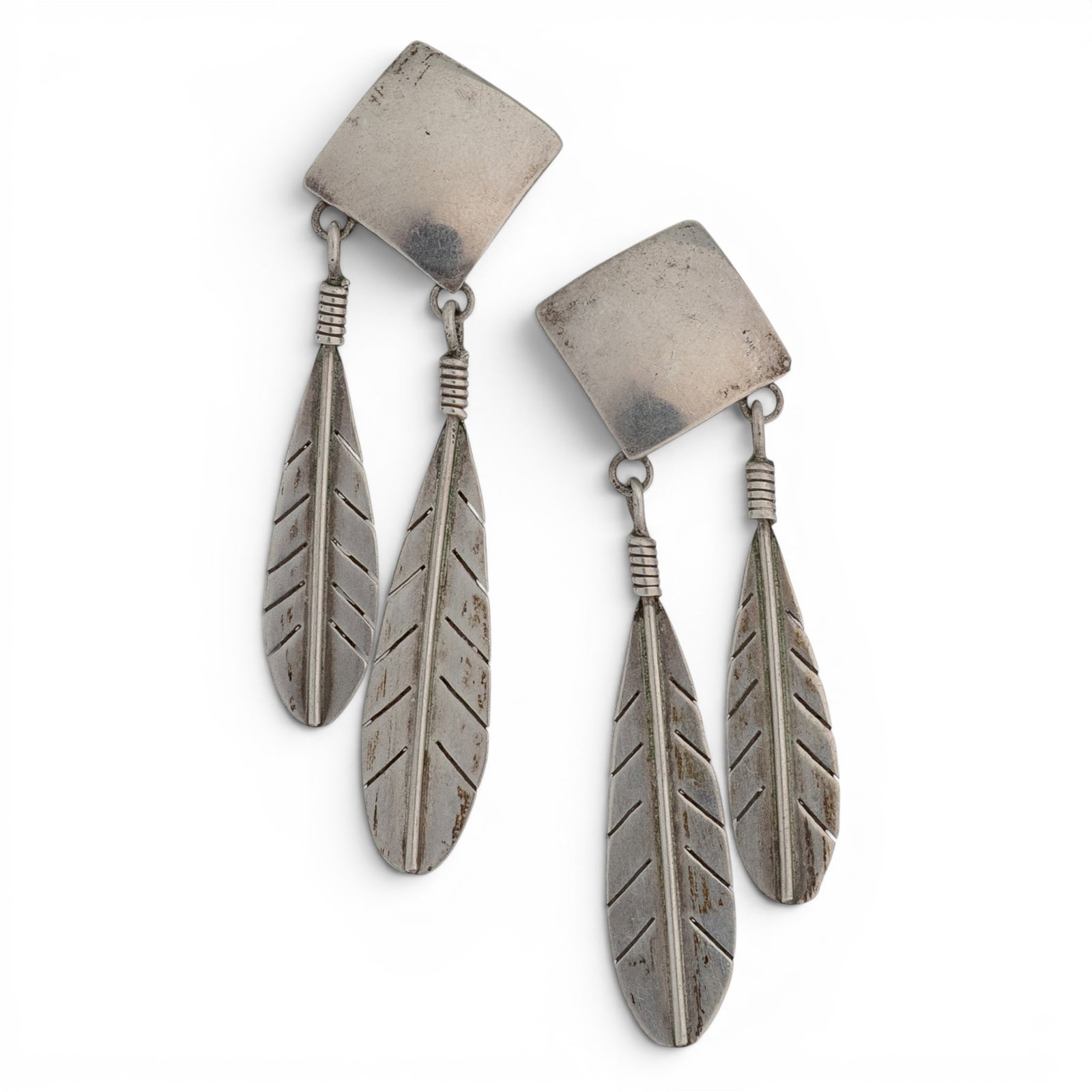 Vintage Clendon Pete Navajo Sterling Silver Feather Dangle Earrings: Vintage Clendon Pete Navajo Sterling Silver Feather Dangle Earrings 1970-1980s, USA Matching pair of handcrafted sterling silver dangle earrings featuring geometric square tops and suspending articula