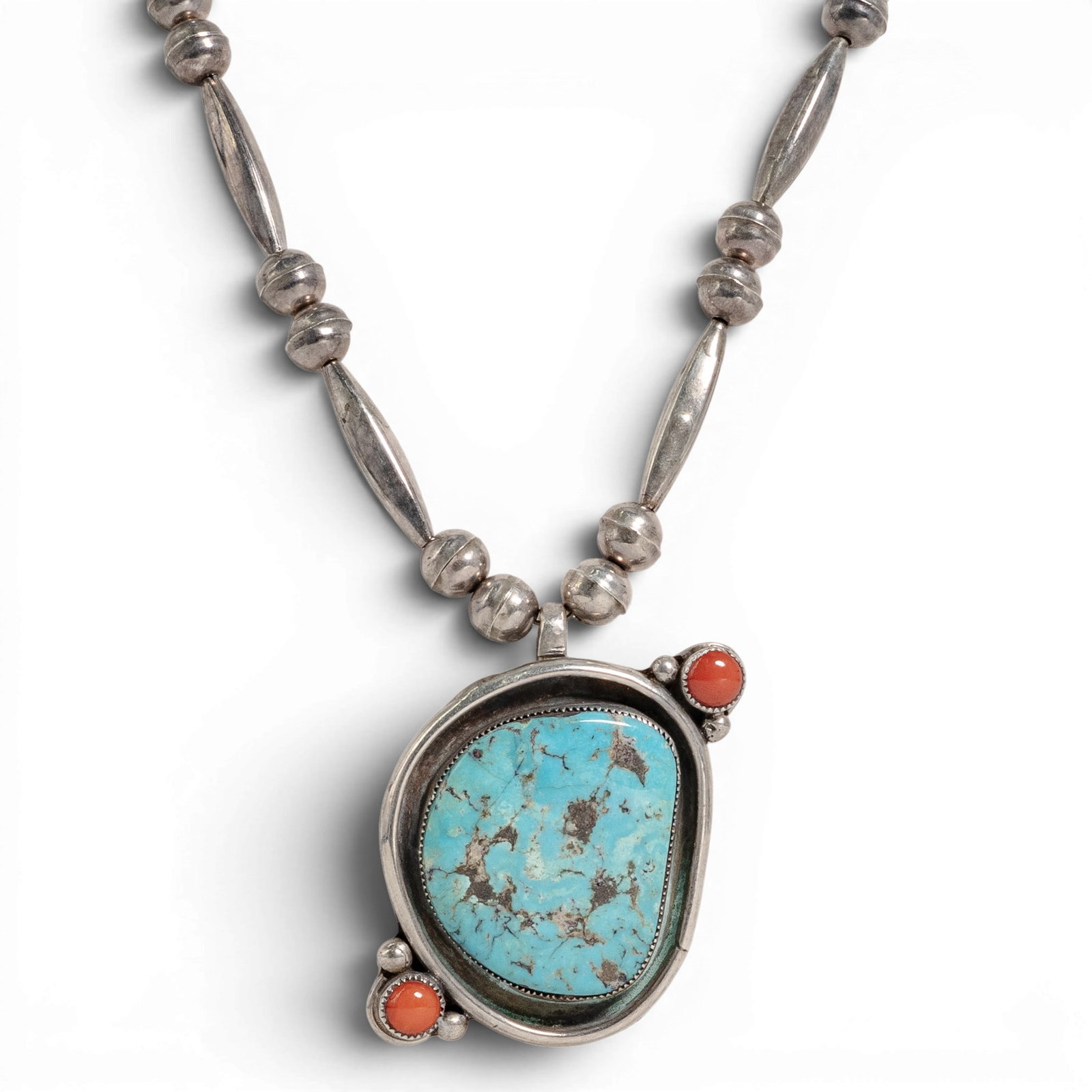 Vintage Navajo Sterling Silver Turquoise & Coral Pendant Necklace: Vintage Navajo Sterling Silver Turquoise & Coral Pendant Necklace 1970-1980s, USA Vintage sterling silver necklace of Navajo bench-made beads in melon and elongated barrel forms, centered by a large n