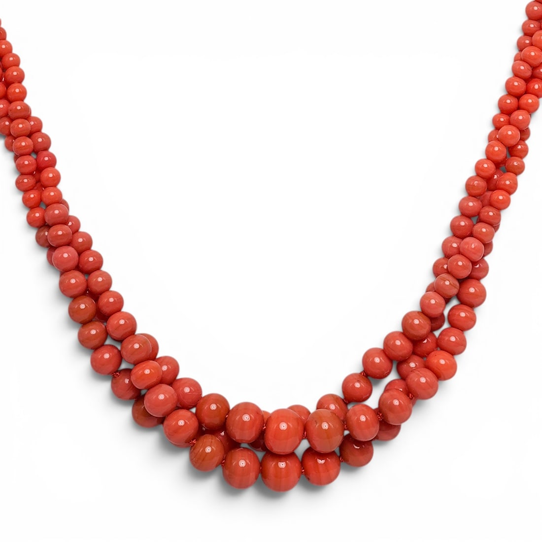 Multi-Strand Coral Bead Necklace: Multi-Strand Coral Bead Necklace 20th Cent. The necklace features three distinct strands of salmon-orange coral beads that graduate in size, with the largest beads positioned at the front center of th