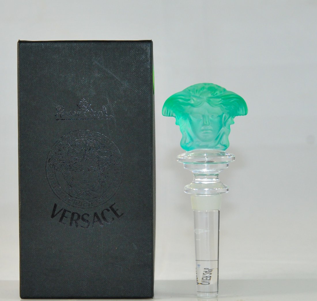 Versace crystal "Double Medusa" light green bottle stop: DESCRIPTION: Versace crystal "Double Medusa" light green bottle stopper. Clear crystal shaft with top rubber ring. Tapering and step crystal neck featuring a double sided light green Medusa head. No c