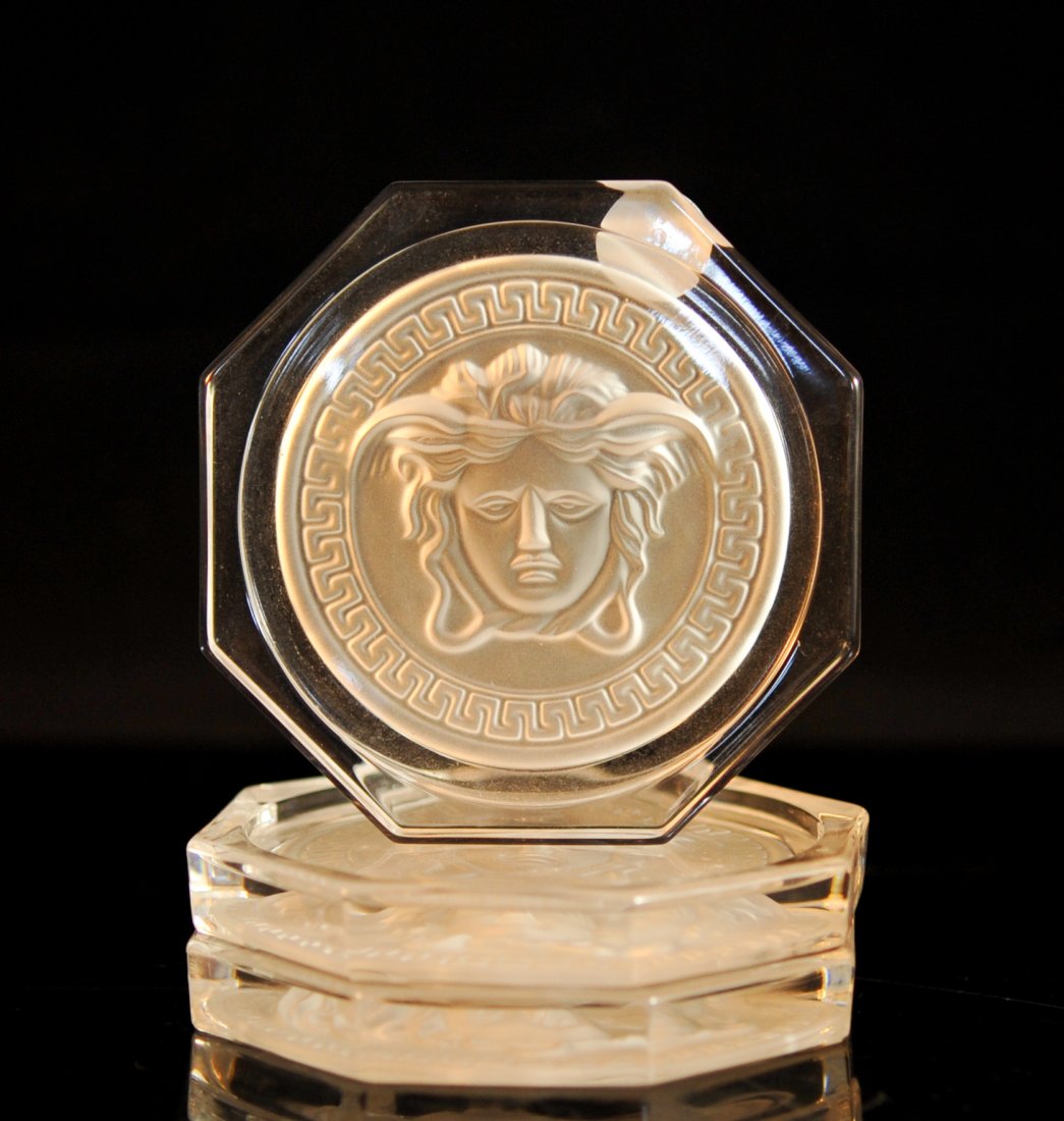 Set of three Versace Lumiere crystal coasters: DESCRIPTION: Set of three Versace Lumiere crystal coasters. Features center concave Medusa heads with a Greek key band border done in frosted crystal. Octagonal body designs. Perfect condition. Signed