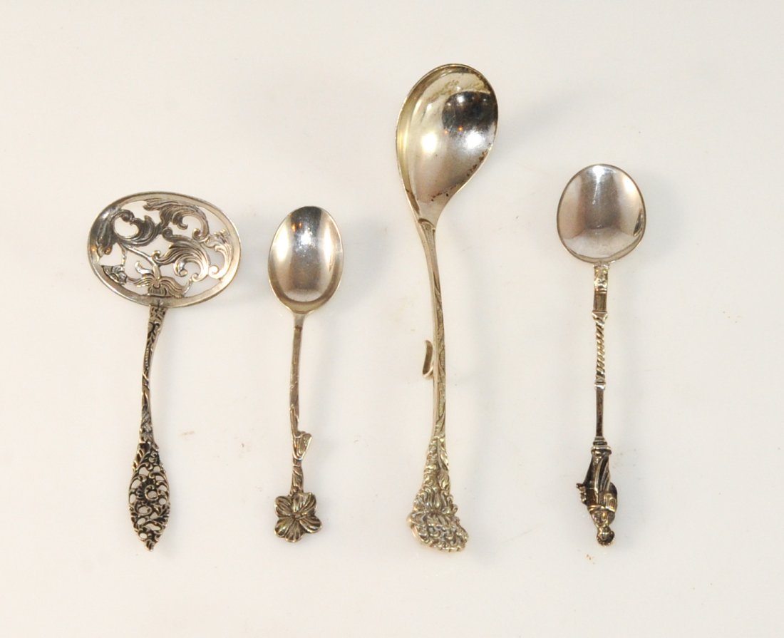 Lot of four misc antique silver spoons: DESCRIPTION: Lot of four misc antique silver spoons. Each spoon different in size and style. Featuring floral and foliate designs with one spoon having a robed figure as the finial of the piece. All t