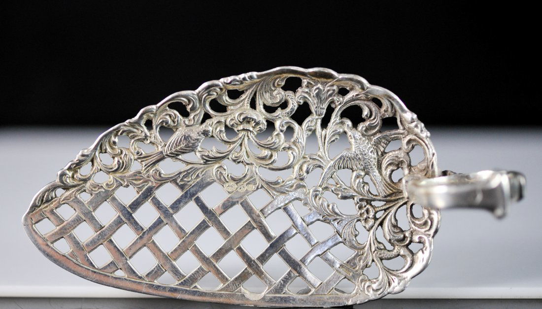 Antique ornate Dutch silver absinthe spoon. Hallmarked: DESCRIPTION: Antique ornate Dutch silver absinthe spoon. Intricately done with baroque design throughout. Features two birds nesting in a flower bush adorned by a checkered cross silver patten. The ha