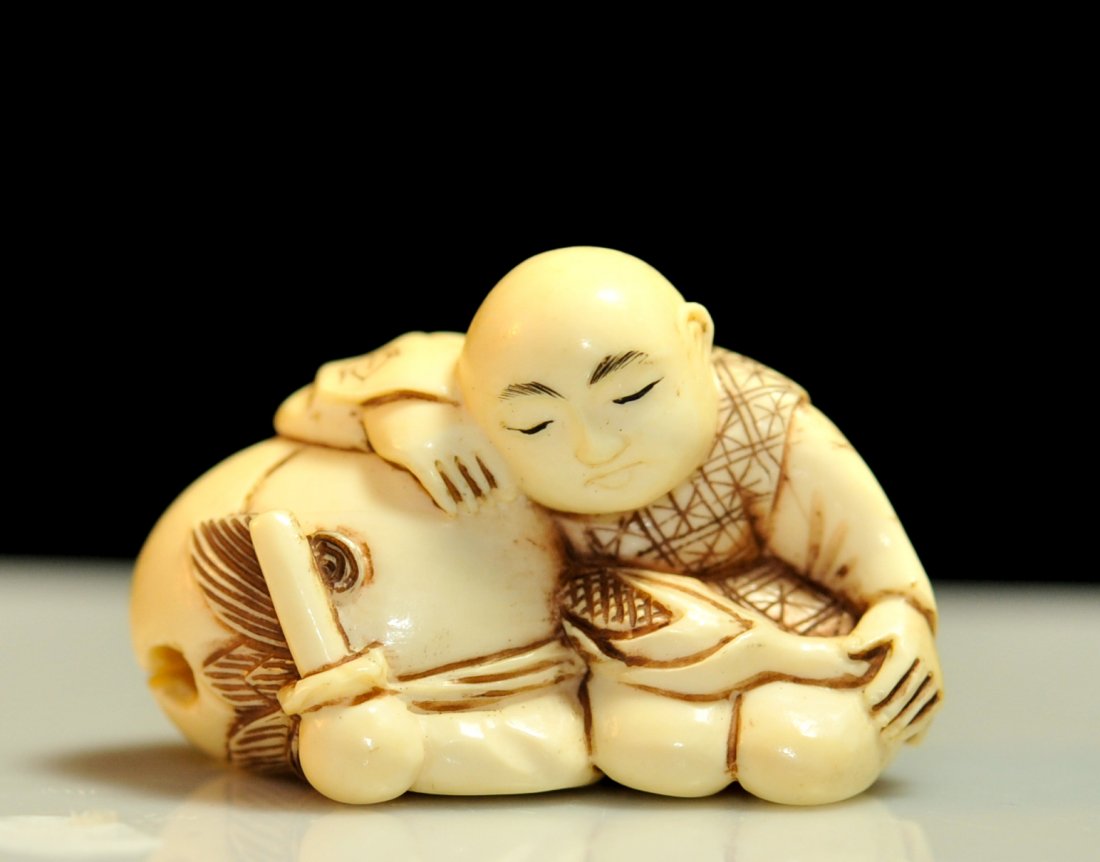 Vintage Asian carved ivory "Sleeping boy" netsuke: DESCRIPTION: Vintage Asian carved ivory "Sleeping boy" netsuke. Features a young boy fast asleep on a giant fruit with a corn stalk on his lap. Great attention to detail. CIRCA: Mid to late 20th Centu