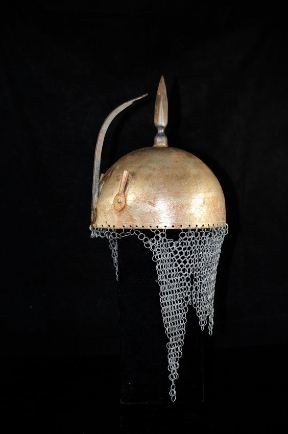 Authentic antique century Islamic nobleman helmet: DESCRIPTION: Authentic antique 19th century Islamic nobleman helmet. Weathered metal with engraved design. Intricately individual carved scenes of exotic birds. Long spike atop with a pivoting nasal g