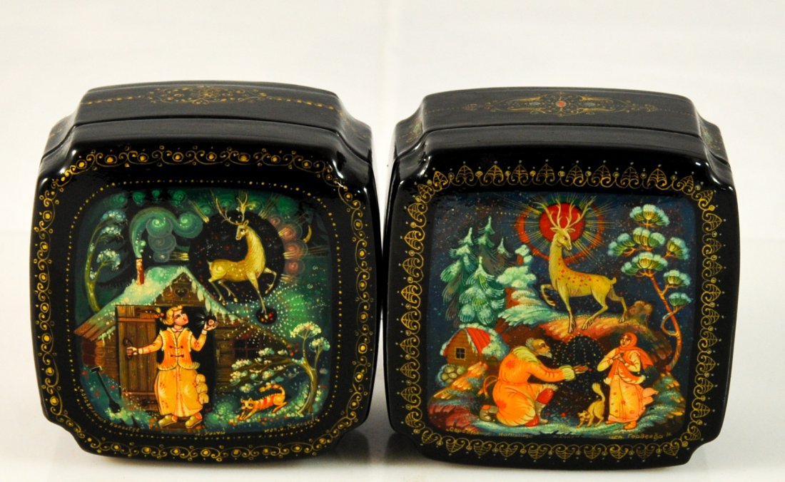 Pair of Soviet Union lacquered art boxes. Signed: DESCRIPTION: Pair of Soviet Union lacquer art boxes. The lid of each box is completely hand painted with folklore scenes. Depiction of Saint Nicholas down on one knee in a festive surroundings. The ot