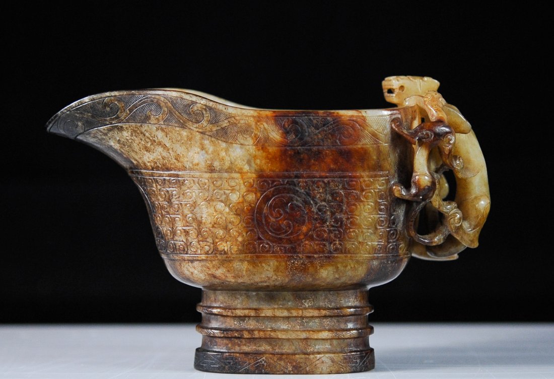 Ming Dynasty Jade pouring vessel with panther handle: DESCRIPTION: Ming Dynasty Jade pouring vessel with panther handle. One solid piece of jade with a double band base. Running border of engraved symbols on the main body with a lightly engraved foliate 