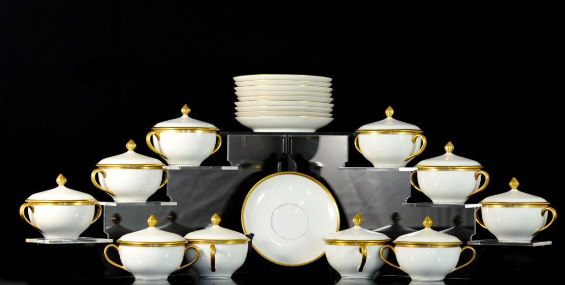 Set of ten Limoges white porcelain tea cups and saucers: DESCRIPTION: Set of ten Limoges white porcelain tea cups and saucers. White ground color with double harp handles and bud style finial. Each tea cup comes with it's own lid. Gold leaf accents througho