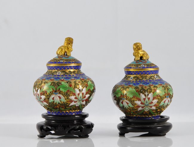 Pair Of Antique Chinese Cloisonne Urns On Bases: Description: Pair Of Antique Chinese Cloisonne Urns On Bases. Features A Mix Of Cloisonne And Champleve Design With A Multi Colored Floral Motif. Ruyi Heads Run The Border Towards The Top With Twin Fo