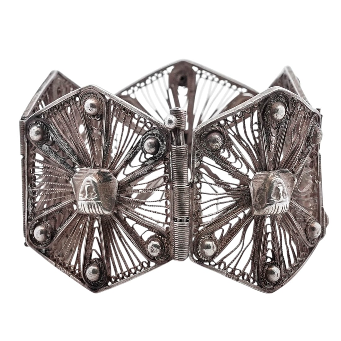 Vintage Egyptian Revival Silver Filigree Panel Bracelet: Vintage Egyptian Revival Silver Filigree Panel Bracelet20th centuryArticulated bracelet composed of hexagonal silver panels, each centered with a raised Egyptian Revival figural motif. The figures are