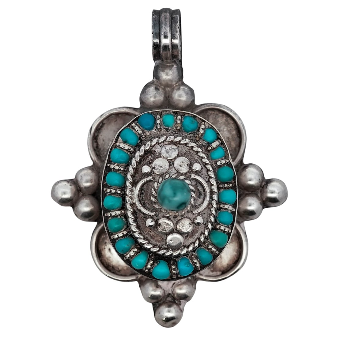Tibetan Sterling Silver Turquoise Pendant: Tibetan Sterling Silver Turquoise PendantLate 20th century, TibetHand-crafted sterling silver pendant of domed form, centered by a round turquoise cabochon, encircled by a halo of small turquoise bead