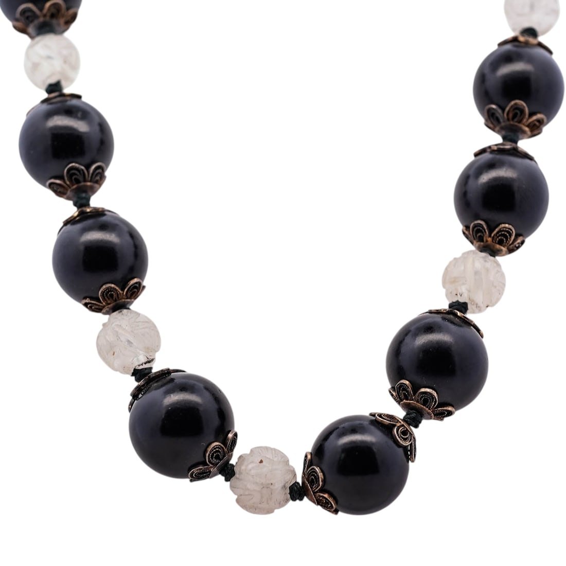 Chinese Wood and Rock Crystal Beaded Necklace: Chinese Wood and Rock Crystal Beaded Necklace20th century, ChineseA Chinese beaded necklace featuring large black wood beads and rock crystal beads with carved "Shou" longevity symbols and silver acce
