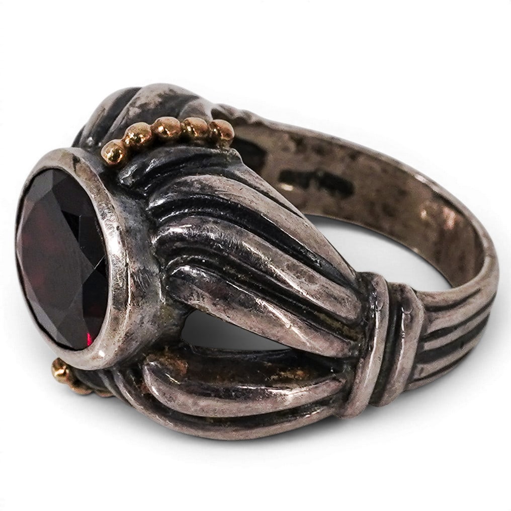 Lagos Caviar Sterling Silver 18k Gold & Garnet Ring: Lagos Caviar Sterling Silver 18k Gold & Garnet Ring 1990s-2000s, USA Lagos Caviar collection ring in sterling silver and 18k yellow gold, designed as a fluted dome bezel-set with an oval faceted