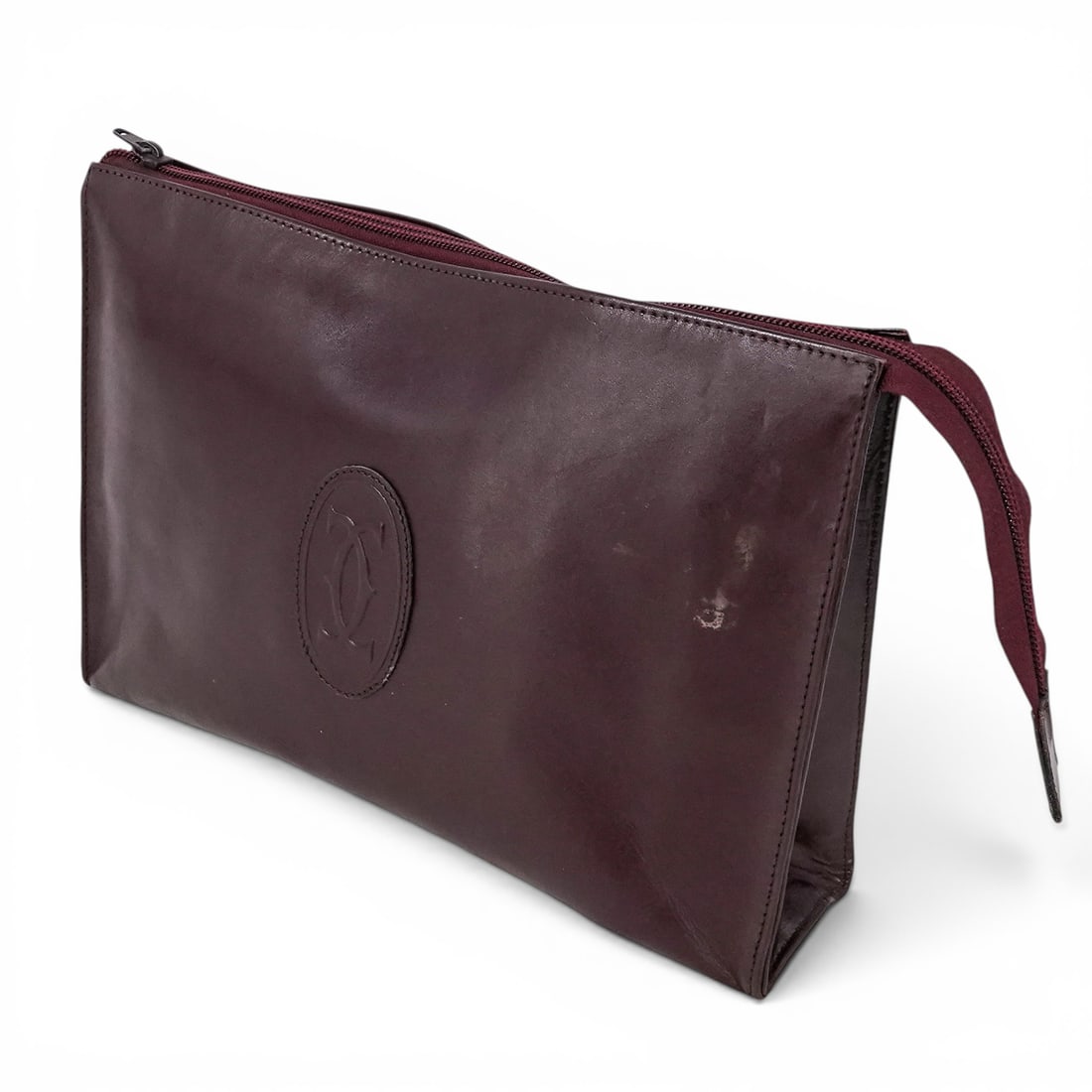 Vintage Cartier Burgundy Leather Clutch: Vintage Cartier Burgundy Leather Clutch Late 20th Century, France Vintage Cartier Burgundy Leather Clutch Pouch featuring the iconic double “C” logo to the front and zip-top closure.