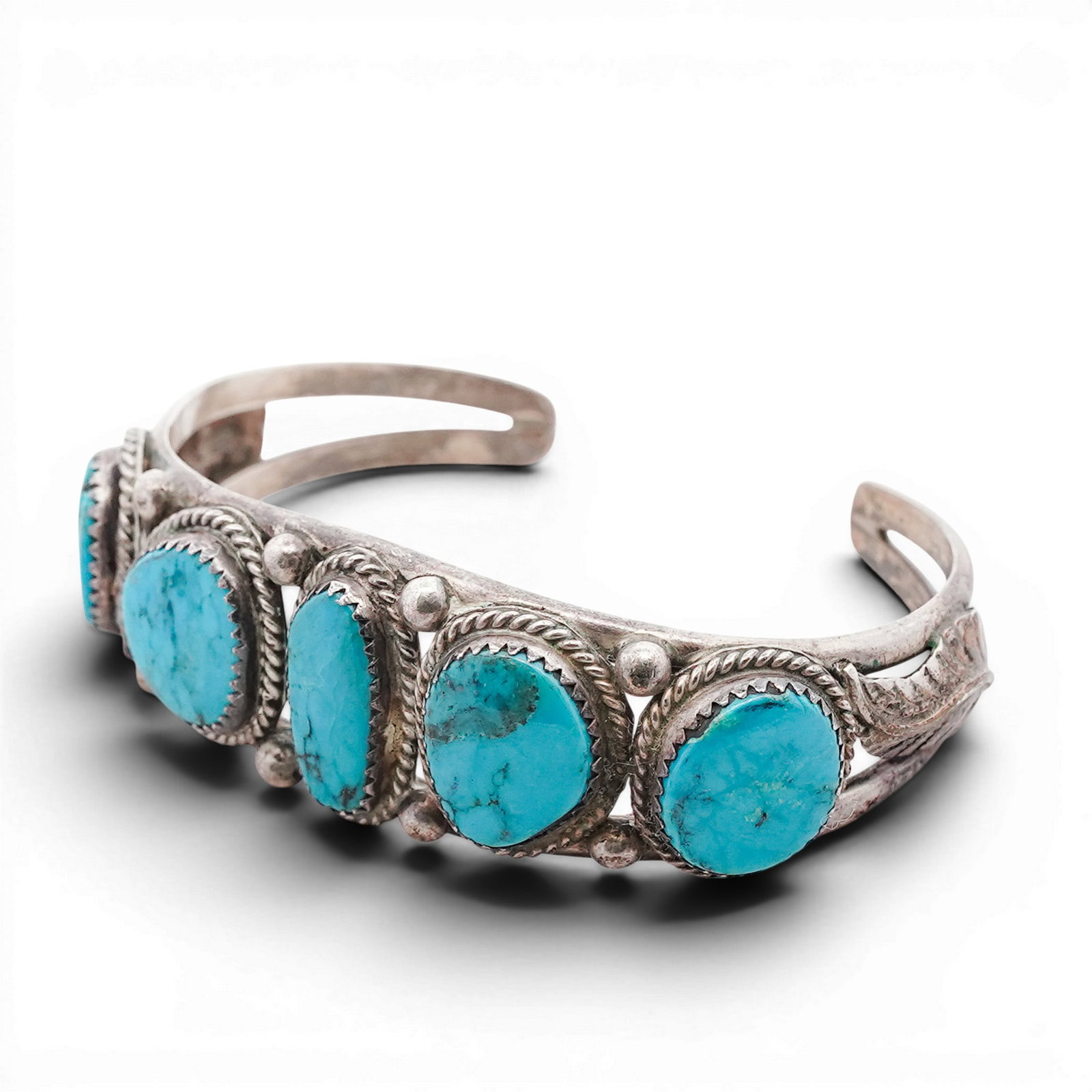 Vintage Navajo Sterling Silver & Turquoise Row Cuff Bracelet: Vintage Navajo Sterling Silver & Turquoise Row Cuff Bracelet 1970s-1980s, USA Hand-fabricated cuff bracelet set with five oval turquoise cabochons in serrated bezels, each framed by twisted rope surro