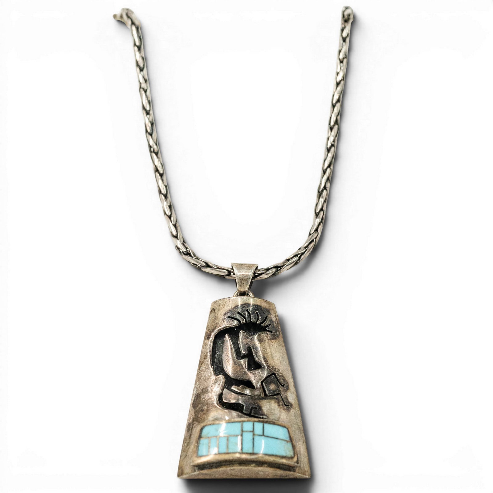Navajo Sterling Silver & Turquoise Kokopelli Pendant Necklace: Navajo Sterling Silver & Turquoise Kokopelli Pendant Necklace 1980s-1990s, USA Navajo sterling silver necklace featuring a braided sterling silver chain with gold-tone accent bands and a large trapezo