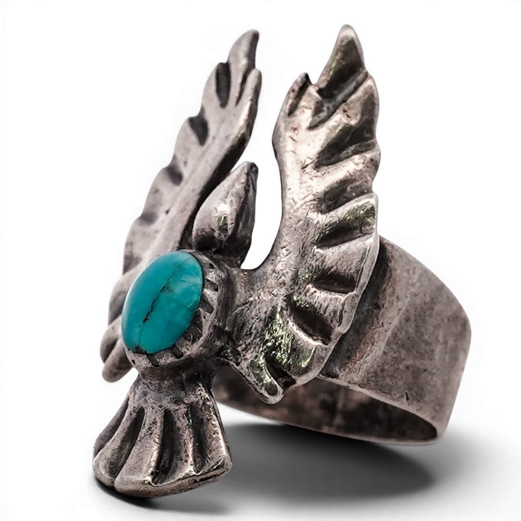 Vintage Navajo Sterling Silver & Turquoise Thunderbird Motif Ring: Vintage Navajo Sterling Silver & Turquoise Thunderbird Motif Ring 1970s-1980s, USA Sterling silver ring formed as a stylized thunderbird with spread wings and stamped feather details. Center set with 