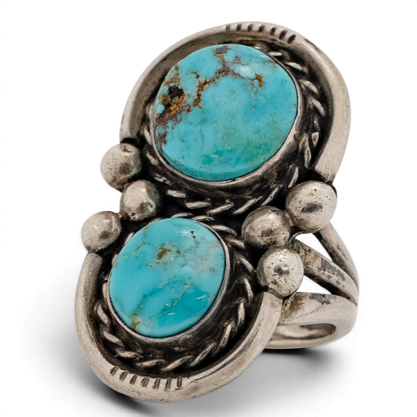 Vintage Navajo Sterling Silver & Double Turquoise Ring: Vintage Navajo Sterling Silver & Double Turquoise Ring 1970s-1980s, USA Vertical double-stone ring set with two oval turquoise cabochons with natural matrix, each in serrated bezels and framed by twis