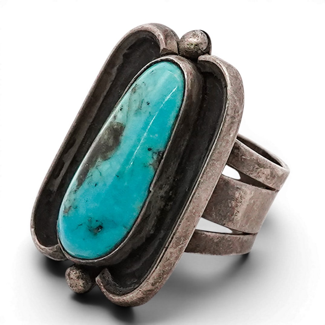 Vintage Navajo Sterling Silver & Turquoise Shadowbox Ring: Vintage Navajo Sterling Silver & Turquoise Shadowbox Ring 1970s-1980s, USA Vintage Navajo sterling silver ring set with an elongated oval turquoise cabochon displaying natural brown matrix. Stone set 