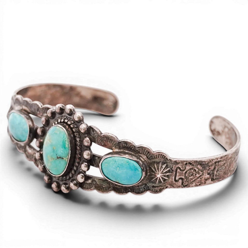 Vintage Navajo Sterling Silver & Turquoise Cuff Bracelet: Vintage Navajo Sterling Silver & Turquoise Cuff Bracelet 1970s-1980s, USA Sterling silver cuff set with three oval turquoise cabochons, the center stone framed by applied beadwork and a rope-twist bez