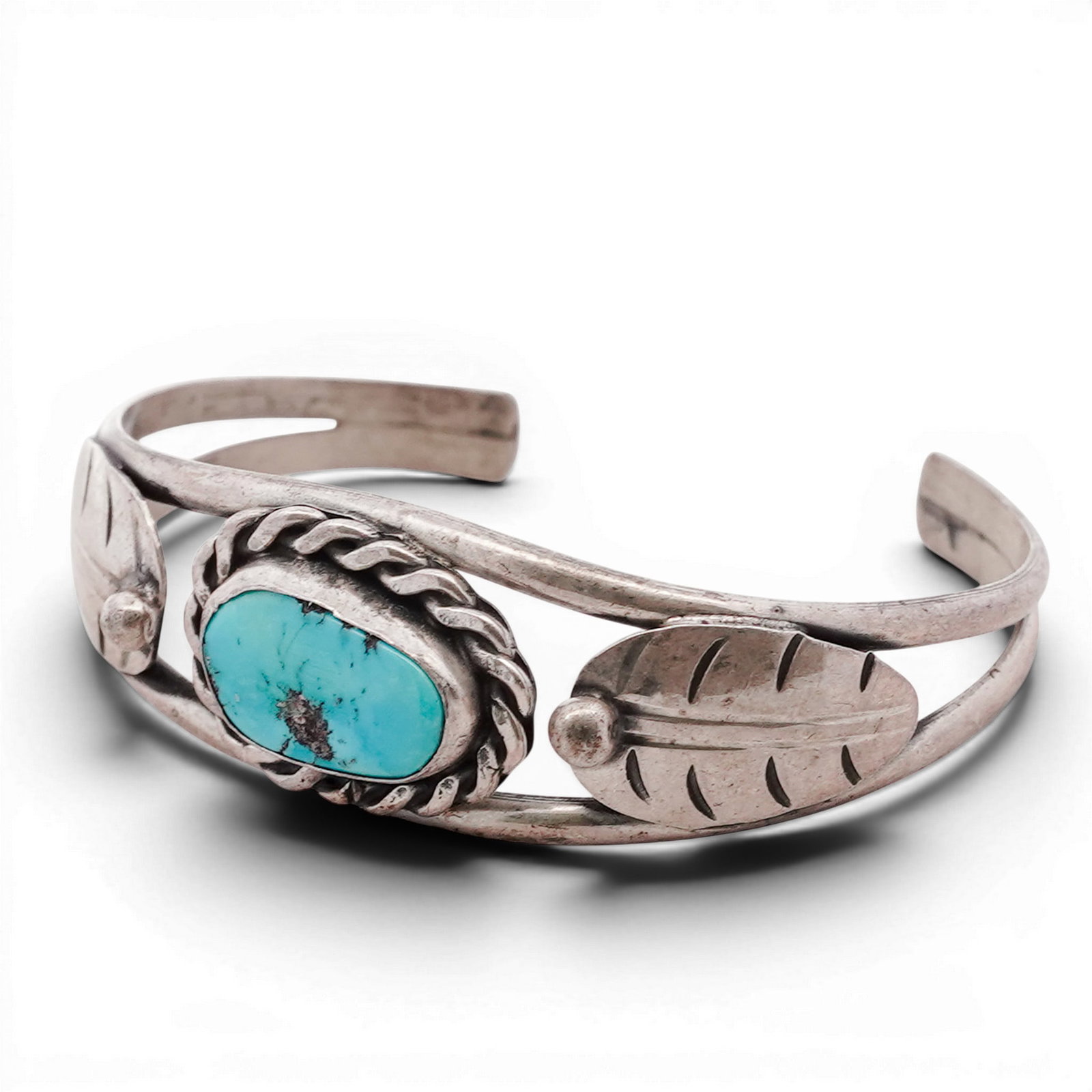 Vintage Navajo Sterling Silver & Turquoise Cuff Bracelet: Vintage Navajo Sterling Silver & Turquoise Cuff Bracelet 1970s-1980s, USA Hand-fabricated cuff bracelet centered with an oval turquoise cabochon set within a twisted rope bezel. The stone is flanked b