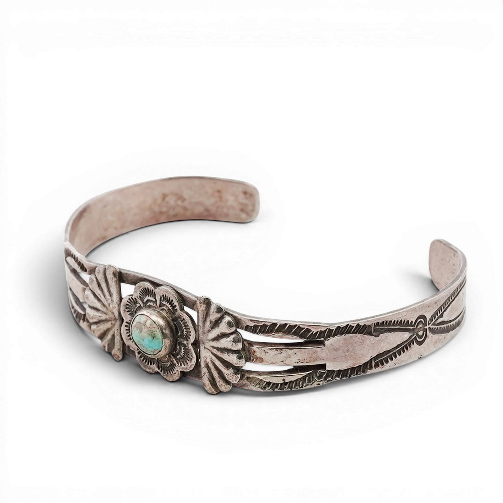 Vintage Navajo Sterling Silver & Turquoise Cuff Bracelet: Vintage Navajo Sterling Silver & Turquoise Cuff Bracelet 1970s-1980s, USA Hand-fabricated cuff bracelet featuring a central round turquoise cabochon set within a stamped floral motif. The design is fl