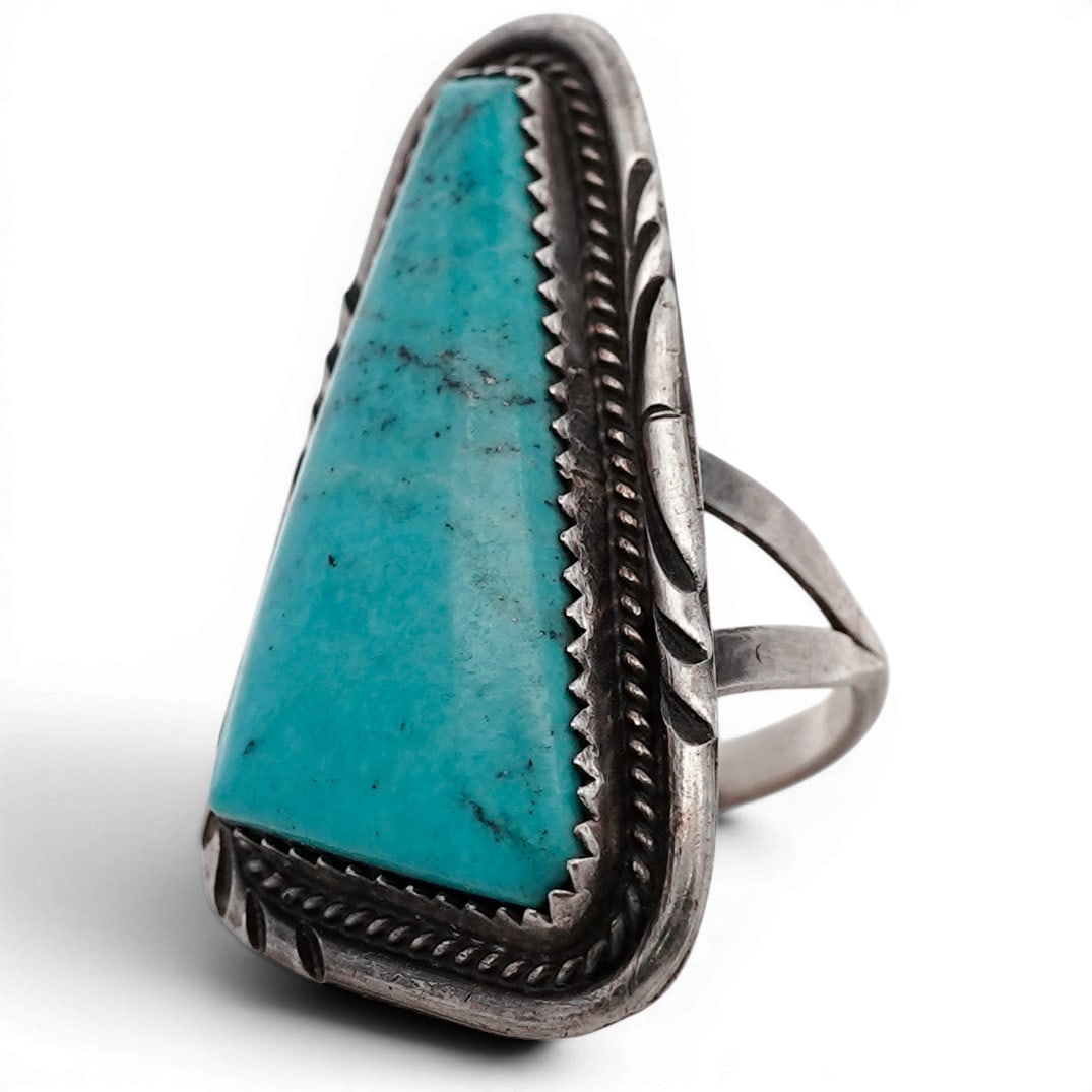 Vintage Navajo Sterling Silver Triangular Turquoise Ring: Vintage Navajo Sterling Silver Triangular Turquoise Ring Vintage sterling silver ring featuring a large, elongated triangular turquoise cabochon with subtle natural matrix. The stone is set within a s