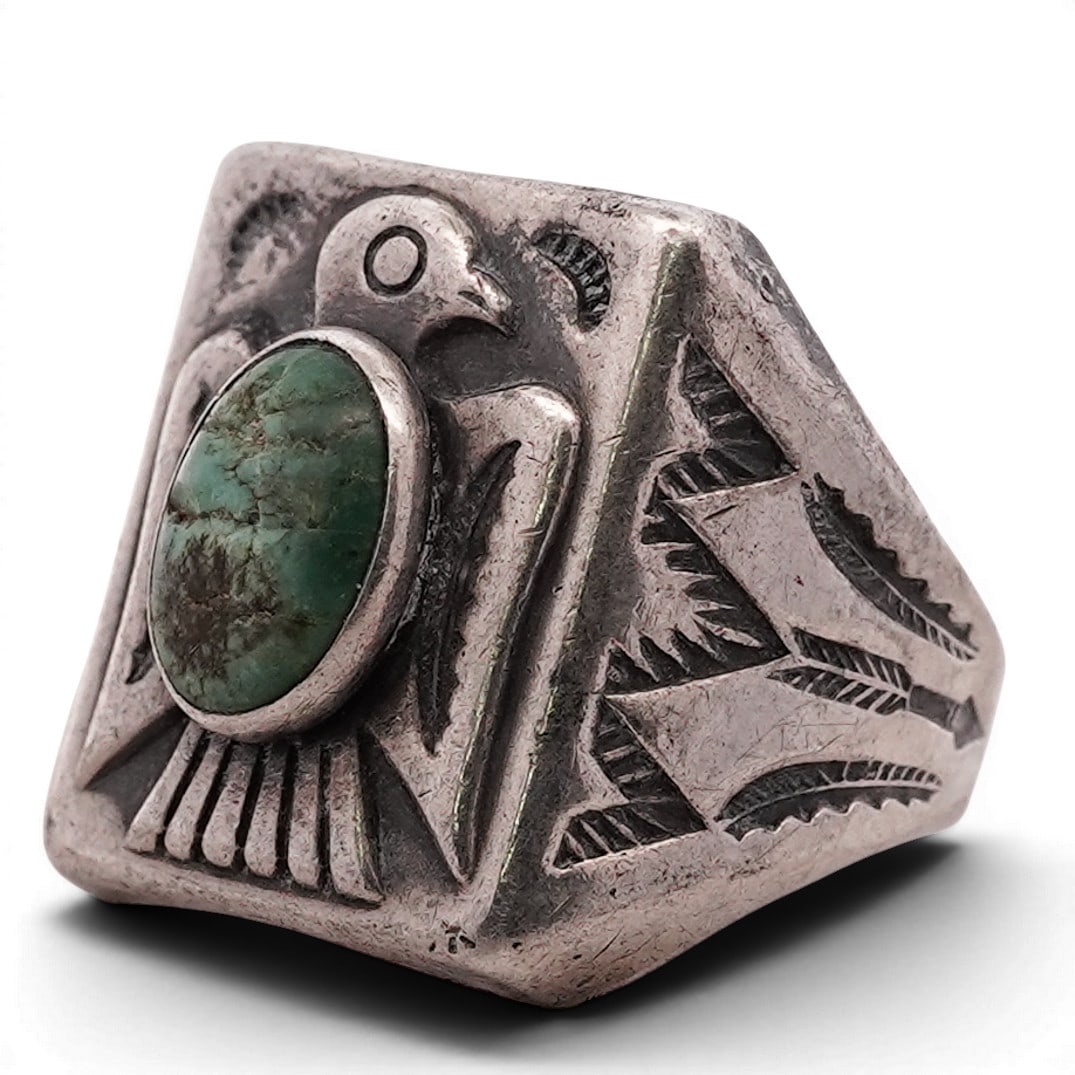 Vintage Navajo Sterling Silver & Green Turquoise Thunderbird Ring: Vintage Navajo Sterling Silver & Green Turquoise Thunderbird Ring 1970s–1980s, USA Sterling silver ring set with an oval green turquoise cabochon within a plain bezel, mounted over a thunderbird mot