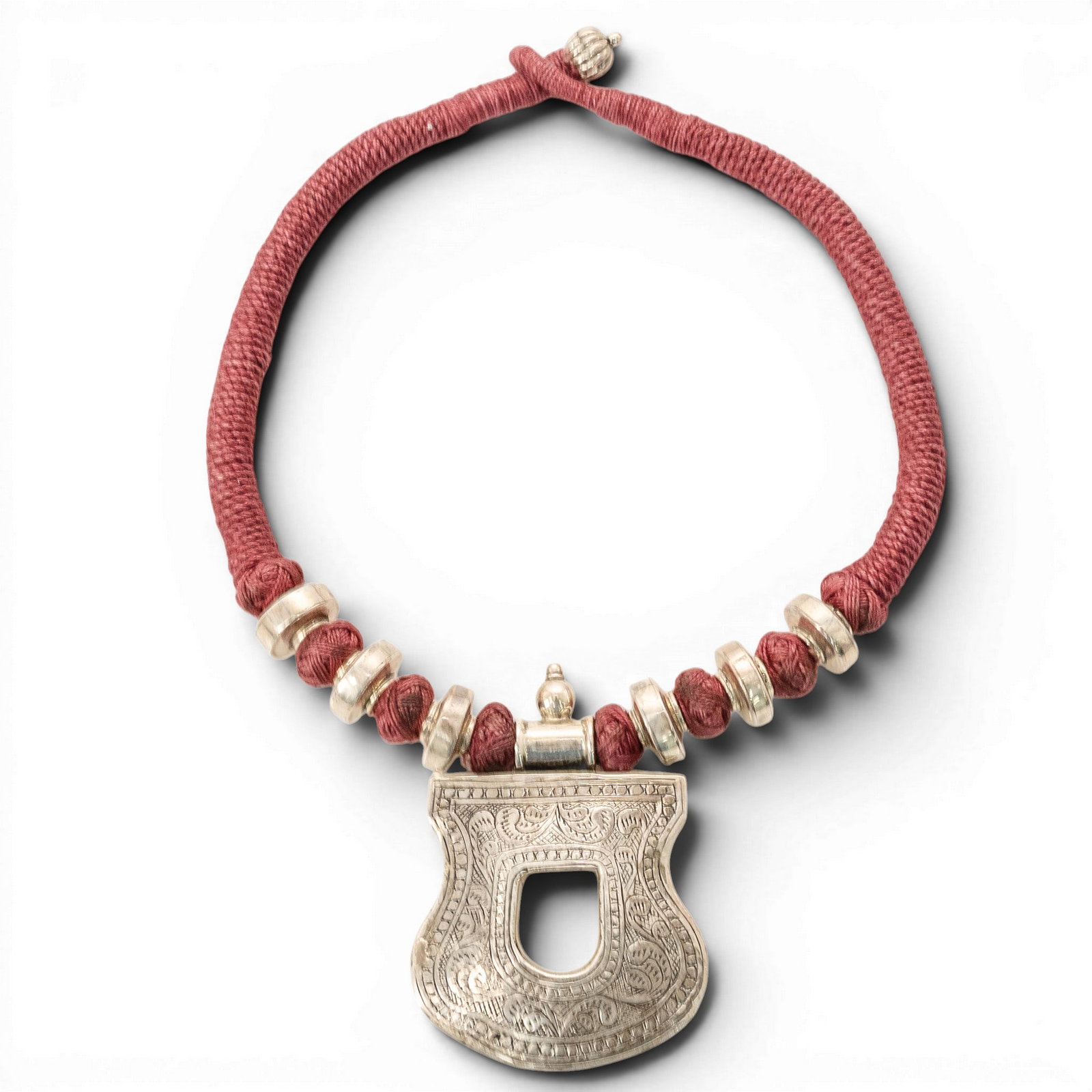 Sterling Silver Repousse Pendant Cord Necklace: Sterling Silver Repousse Pendant Cord Necklace Late 20th Century Sterling silver cord necklace featuring a red wrapped cord with sterling silver bead accents and a large shaped repoussé pendant. Pend