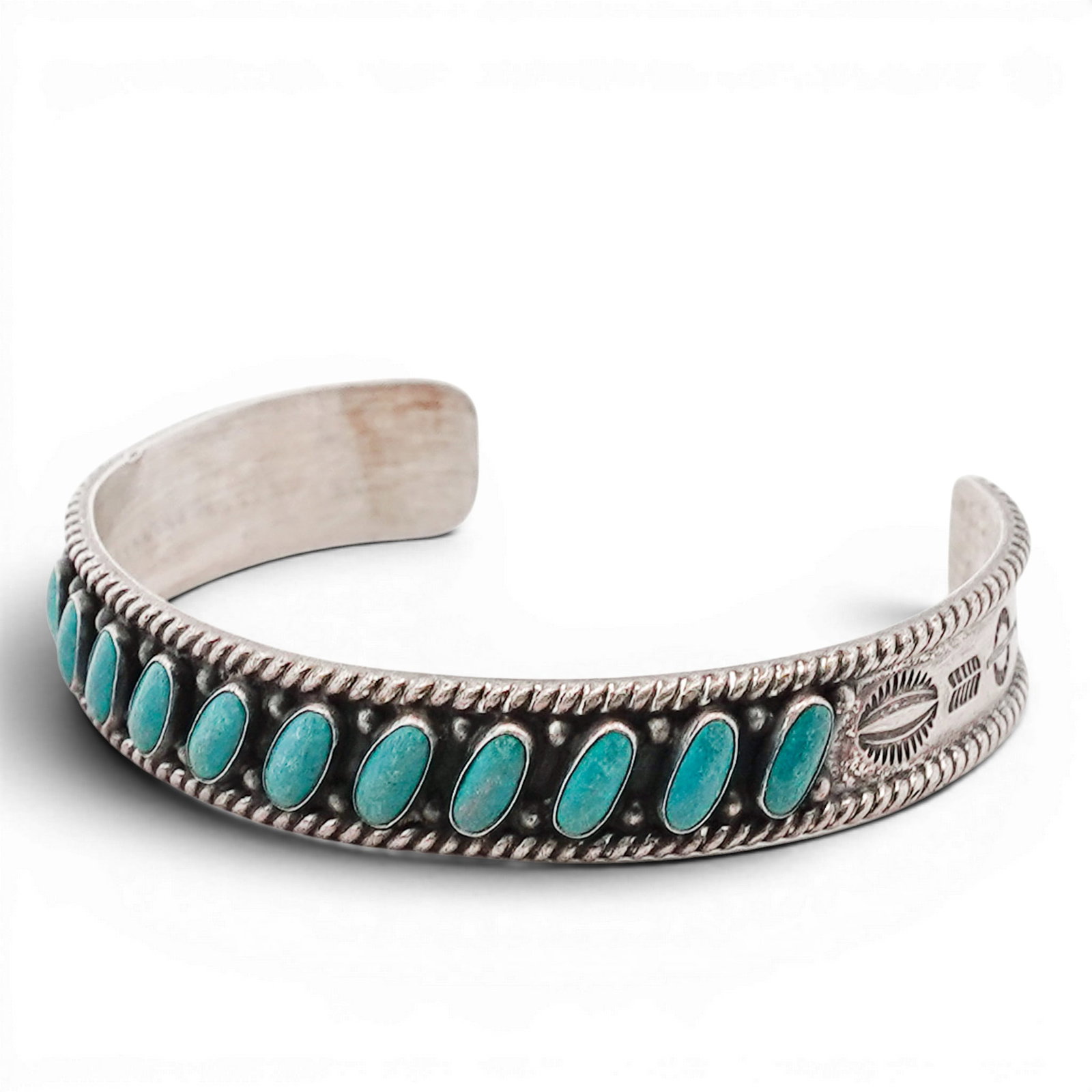 Vintage Navajo Sterling Silver & Turquoise Row Cuff Bracelet: Vintage Navajo Sterling Silver & Turquoise Row Cuff Bracelet 1970s-1980s, USA Sterling silver cuff set with a continuous row of oval turquoise cabochons in bezel settings, bordered by twisted wire and