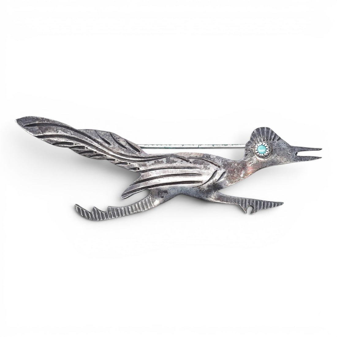 Vintage Navajo Sterling Silver Turquoise Eye Roadrunner Brooch: Vintage Navajo Sterling Silver Turquoise Eye Roadrunner Brooch 1940s-1970s, USA Stylized roadrunner brooch formed in sheet silver with incised feather detailing and elongated tail. The eye is set with