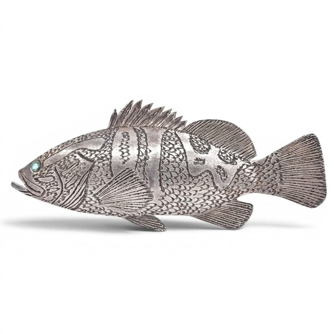 R. Adye Sterling Silver Engraved Fish Brooch: R. Adye Sterling Silver Engraved Fish Brooch 1991, USA Hand-fabricated figural fish brooch with detailed engraved surface decoration and applied fin elements. The eye is set with a small green stone. 