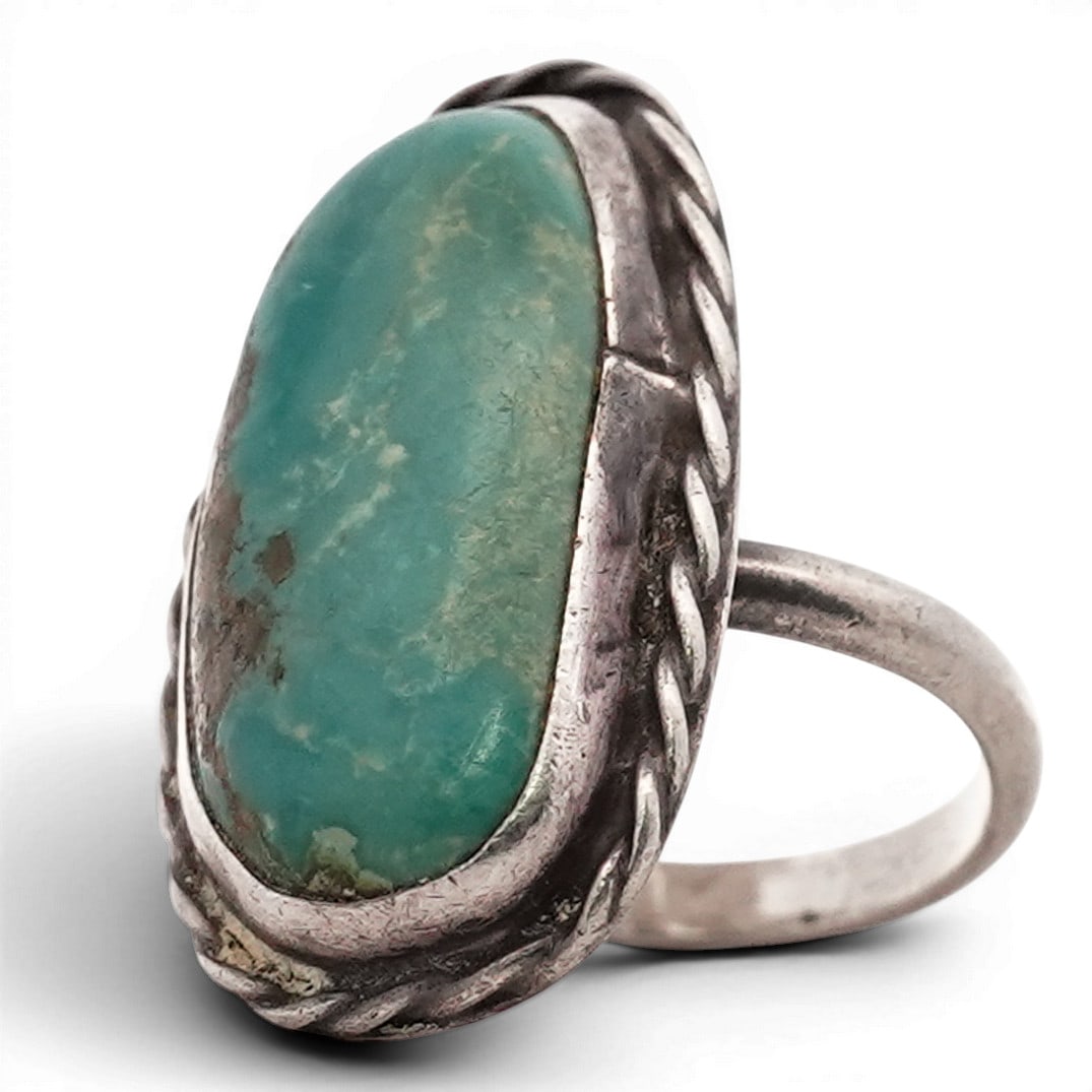 Vintage Navajo Sterling Silver Freeform Turquoise Ring: Vintage Navajo Sterling Silver Freeform Turquoise Ring Late 20th Century, USA Vintage sterling silver ring set with an oval turquoise cabochon displaying green-blue coloration with natural brown matri